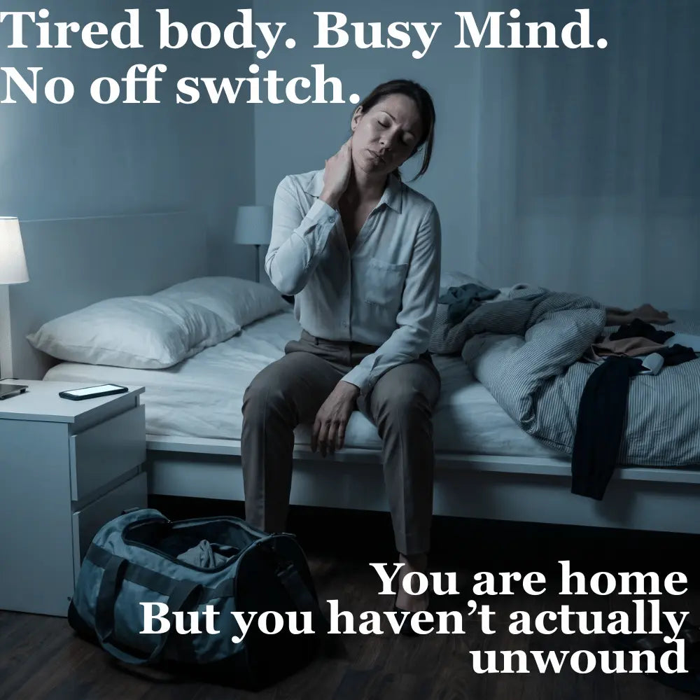 Tired woman sitting on the edge of her bed at night holding her tight neck